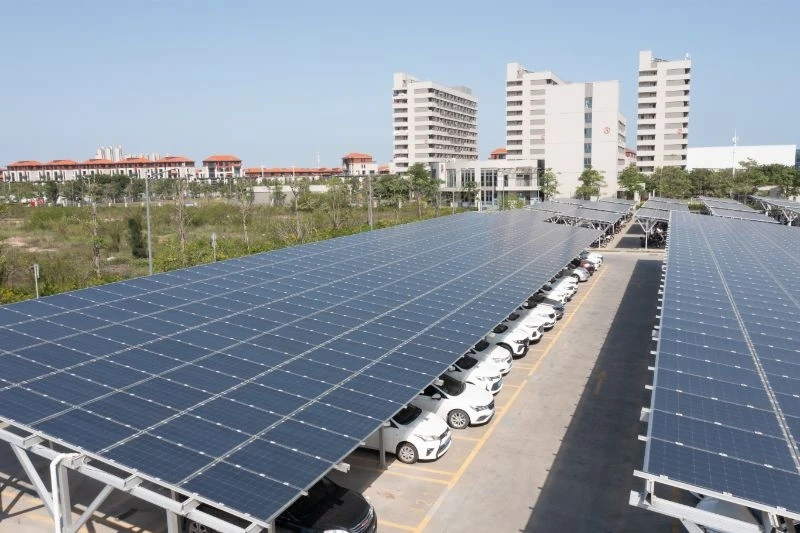 Carport fotovoltaico installato sopra un ampio parcheggio aziendale con auto in sosta