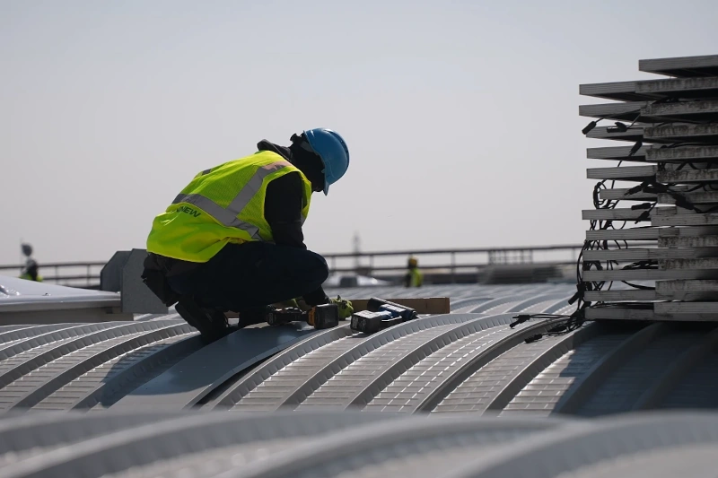 Tecnico al lavoro su una copertura industriale durante un intervento di riqualificazione Tecnico al lavoro su una copertura industriale durante un intervento di riqualificazione